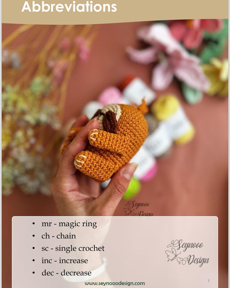 Puede incluir: Primer plano de un juguete de amigurumi de perezoso tejido a crochet en colores marr&oacute;n y naranja. El juguete est&aacute; siendo sostenido por una mano. La imagen incluye el texto "Seynoo Design" y "Abbreviations" con una lista de abreviaturas de crochet.