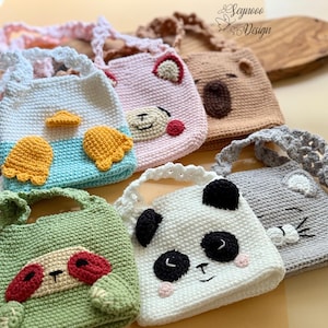 Könnte beinhalten: Eine Sammlung handgefertigter Häkeltaschen in verschiedenen Farben und Tiermotiven. Die Taschen zeigen Gesichter von Panda, Koala, Bär, Faultier und anderen Tieren. Jede Tasche hat ein einzigartiges Design und Farbschema mit Details wie Ohren und Gesichtszügen.