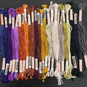 Puede incluir: Una colecci&oacute;n de 20 carretes de hilo de bordar en varios colores, incluyendo morado, azul, verde, amarillo, naranja, rojo, marr&oacute;n y negro. Los carretes est&aacute;n etiquetados con el nombre de la marca "Oasis" e "Hilo de bordar".