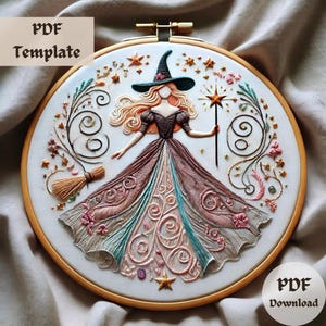 May include: Embroidered witch design in a wooden hoop. The witch wears a black hat and a long dress with brown, pink, and teal accents. The design includes stars, flowers, a broom, and the text "PDF Template" and "PDF Download".