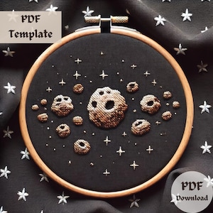 May include: Embroidered hoop art featuring a dark background with gold and white stars and a cluster of gold asteroids. The text "PDF Template" and "PDF Download" are visible in the image.