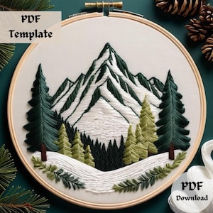 May include: Embroidered hoop art featuring a snowy mountain range with evergreen trees. The mountain peaks are white with green accents. The trees are green with white accents. The background is white with a light blue sky. The hoop is made of wood and has a natural finish.