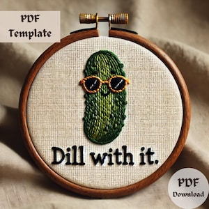 Puede incluir: Arte de bordado en aro con un pepinillo verde con gafas de sol y el texto "Dill with it."