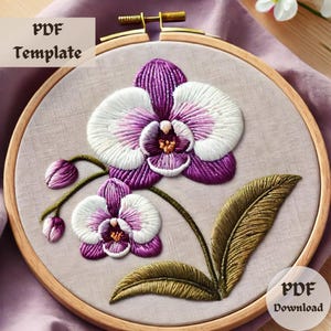 以下が含まれることがあります： 紫と白の蘭の花と緑の葉の刺繍パターン。パターンは木製の刺繍枠に表示されています。画像には「PDF Template」と「PDF Download」のテキストが表示されています。