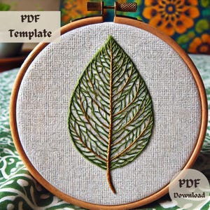 May include: A green leaf embroidery pattern on white fabric in a wooden embroidery hoop. The pattern is detailed and intricate, with a delicate stem and veins. The text "PDF Template" and "PDF Download" is visible in the image.