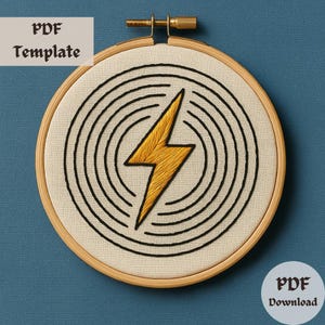 Könnte beinhalten: Eine PDF-Vorlage zum Sticken mit einem gelben Blitz-Design in einem Kreis aus konzentrischen schwarzen Linien. Das Design ist auf einem beigefarbenen Stoffhintergrund.