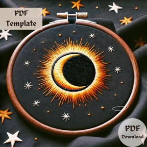 May include: A black embroidery hoop with a gold sunburst design and a crescent moon in the center. The hoop is on a dark fabric background with white stars.