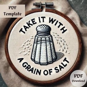 May include: Embroidered hoop art with a salt shaker and the text "Take it with a grain of salt".