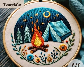 May include: Embroidered hoop art featuring a campfire, tent, and trees under a starry night sky. The design is surrounded by a border of green leaves and colorful flowers.