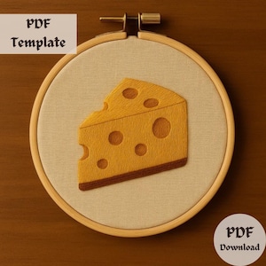 Pode incluir: Um close-up de um aro de bordado bege com uma cunha de queijo amarela bordada com furos. O aro de bordado está sobre uma superfície de madeira marrom. O texto "PDF Template" está no canto superior esquerdo da imagem. O texto "PDF Download" está no canto inferior direito da imagem.
