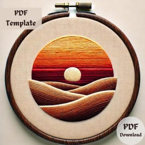 May include: Embroidered sunset landscape with a brown wooden hoop. The embroidery features a red, orange, and yellow sunset over a series of brown hills. The text "PDF Download" is visible in the lower right corner.