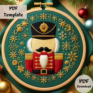 May include: An embroidered Christmas-themed design featuring a nutcracker soldier in a wooden hoop. The nutcracker is dressed in a red jacket, black hat, and white hair. The background is teal with gold snowflakes and floral accents. Text reads "PDF Template" and "PDF Download".