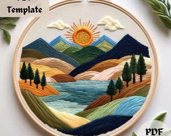 Könnte beinhalten: Stickbild in einem Stickrahmen mit einer Landschaftsszene mit Bergen, einem See und einer Sonne. Die Stickerei ist in Blautönen, Grüntönen, Gelb und Braun gehalten.