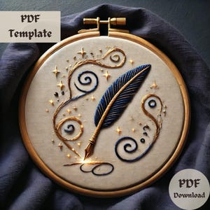 Könnte beinhalten: Ein goldener Stickrahmen mit weißem Stoffhintergrund. Der Stoff ist mit einer blauen und goldenen gestickten Feder mit Schnörkeln und Sternen verziert.