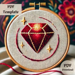 May include: Embroidered diamond design on a round piece of fabric in a wooden embroidery hoop. The diamond is red with gold stitching and there are three gold stars around it.