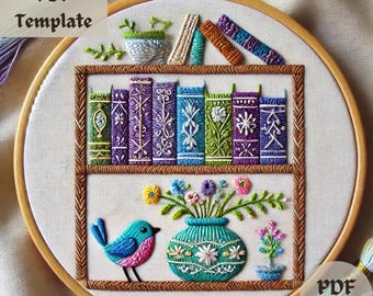 May include: Embroidered hoop art featuring a bookshelf with colorful books, a vase of flowers, and a blue bird. The bookshelf is decorated with a brown border and a white background.