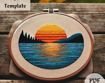 Puede incluir: Arte de bordado en aro que representa una puesta de sol sobre un lago con una cordillera de montañas en el fondo. La puesta de sol es un degradado de naranja, amarillo y rojo, con un lago azul que refleja los colores. La cordillera de montañas es azul oscuro y los árboles son verde oscuro.
