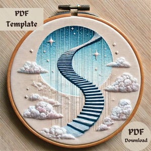 Könnte beinhalten: Stickerei-Hoop-Kunst mit einer blauen und weißen Treppe, die zu einem Himmel mit Sternen und Wolken führt. Der Hoop ist aus Holz und hat einen beigefarbenen Stoffhintergrund.