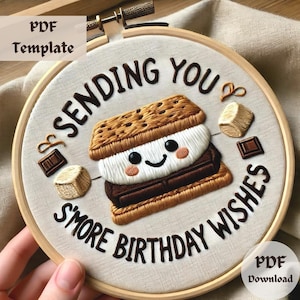 May include: Embroidered hoop art featuring a s'more design with the text "Sending you s'more birthday wishes".