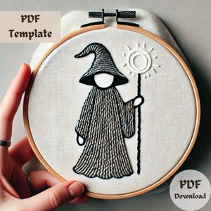 Könnte beinhalten: Stickbild mit Stickerei, das einen schwarz-weißen Zauberer zeigt, der einen Stab mit einem Sonnendesign hält. Der Text "PDF Template" und "PDF Download" ist auf dem Bild sichtbar.