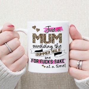 May include: White ceramic mug with a pink and black leopard print design. The mug reads "Just a MUM surviving the SUMMER HOLS one "FOR FUCKS SAKE" at a time!"