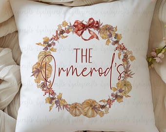 May include: White throw pillow with a fall-themed wreath design. The wreath is made of leaves, berries, and pumpkins. The text "THE Ormerod's" is in the center of the wreath.