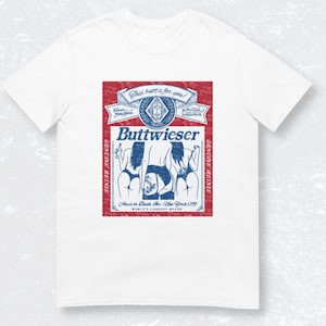 Peut inclure: Une &eacute;tiquette de bi&egrave;re de style vintage avec un fond rouge et du texte bleu. L'&eacute;tiquette pr&eacute;sente un logo avec un lion et le texte "Buttwieser" en caract&egrave;res gras. L'&eacute;tiquette comprend &eacute;galement le texte "Genuine Heinie" et "World's Largest Beers".