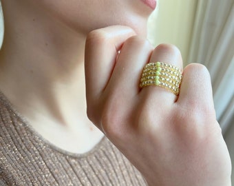 Feminin elastisk ring i gult med en grön glaspärla, en storlek passar alla, elegant ring, stapelbar ring, ring med färgglada pärlor, tunn ring med pärlor