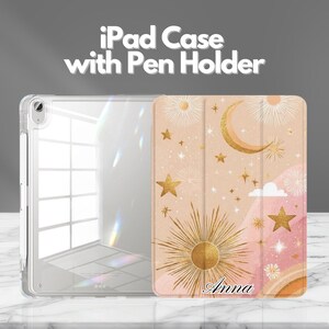 May include: An iPad case with a pen holder. The case is clear with a patterned cover featuring a sun, moon, and stars in gold on a peach background. The name "Anna" is printed in script at the bottom.