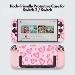 Pode incluir: Uma capa protetora compatível com a base para consolas Switch 2 e Switch. A capa apresenta um fundo rosa claro com um padrão repetitivo de corações desenhados à mão em rosa escuro, cobrindo a consola e os comandos destacáveis.
