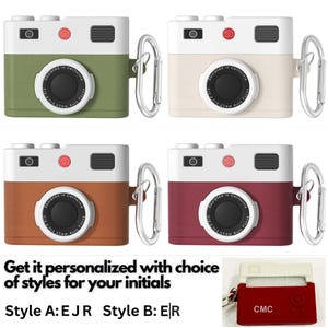 May include: Four different colored camera-shaped phone cases with a carabiner clip. The cases are green, white, brown, and red. The cases have a black lens and the text "Designed in California" on the front. The text "F2.2 37mm Auto Focus" is also on the front of the cases.
