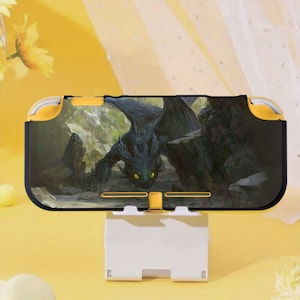 May include: A black and yellow Nintendo Switch Lite case featuring a dragon graphic. The case is supported by a white stand. The dragon is dark green with yellow eyes and is set against a rocky background.