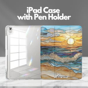 Könnte beinhalten: Transparente iPad-Hülle mit farbenfrohem Cover mit einer Strandszene mit Sonnenuntergang, Wellen und dem Namen "Anna". Die Hülle hat einen Stifthalter und den Text "iPad Case with Pen Holder".