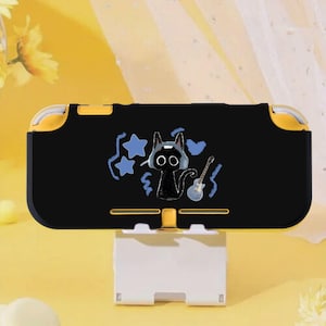 Pode incluir: Capa preta e amarela para Nintendo Switch Lite com um gato de desenho animado usando fones de ouvido e tocando guitarra. A capa tem um centro preto com detalhes amarelos e um suporte branco.