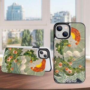 May include: A set of two phone cases with a mosaic design. The cases feature a wave design with green, orange, and white elements, and small orange flowers. One case is open, revealing the phone's screen. The name "Anna" is written on one case.
