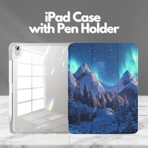 May include: A clear iPad case with a pen holder featuring a tri-fold cover printed with a snowy mountain landscape under a vibrant green aurora borealis and starry night sky. The text iPad Case with Pen Holder is displayed above the product.