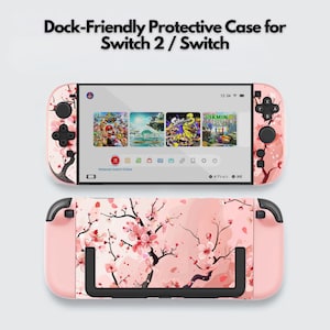 Puede incluir: Una funda protectora rosa para Switch 2 / Switch, con un diseño de flores de cerezo. La funda tiene agarres y botones negros. La pantalla muestra iconos de juegos. El texto "Dock-Friendly Protective Case for Switch 2 / Switch" está en la parte superior.
