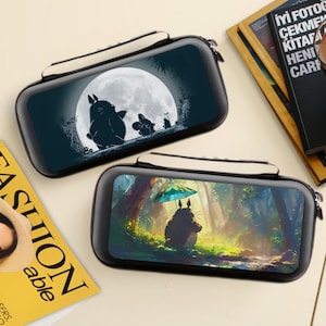 Pode incluir: Duas capas pretas com fecho de correr. Uma capa apresenta uma silhueta de Totoro e seus amigos em frente a uma lua cheia. A outra capa mostra Totoro sob um guarda-chuva em uma cena de floresta.