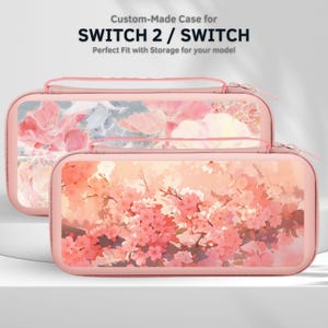 May include: Two pink Switch cases with floral designs. The cases have a zipper closure and a handle. The top case has a watercolor floral design with pink and white flowers. The bottom case has a cherry blossom design. The text on the top says "Custom-Made Case for SWITCH 2 / SWITCH".