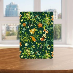 Puede incluir: Un objeto decorativo rectangular con un fondo verde oscuro que presenta una escena de estanque caprichosa. El diseño incluye varias criaturas acuáticas, nenúfares y otras plantas acuáticas en tonos naranja, amarillo y verde.