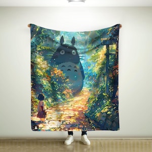 May include: A large, blue blanket featuring a scene from the animated film, My Neighbor Totoro. The design shows Totoro in a forest setting with a young girl. The blanket is held up by a person wearing white sneakers and blue jeans.