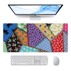 Pode incluir: Um tapete de secretária retangular com um design de patchwork colorido com vários padrões, incluindo azul com silhuetas pretas, preto com cerejas vermelhas, laranja com flores azuis, floral roxo, xadrez amarelo e vermelho com cerejas brancas.