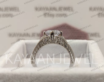 May include: A silver engagement ring featuring a large, clear, round-cut diamond. The ring has a delicate, ornate design with intricate details.