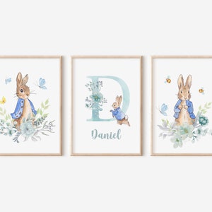 May include: Three watercolour prints featuring a bunny rabbit in a blue jacket, a floral letter D, and the name "Daniel".