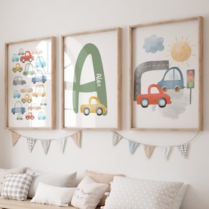 Op de afbeelding: Drie ingelijste prints met een aquarelthema. De eerste print toont een groene letter A met de naam Alex eronder. De tweede print toont een aquarel-illustratie van een weg met auto's en een verkeerslicht. De derde print toont een aquarel-illustratie van een weg met veel auto's in verschillende kleuren.