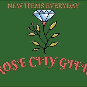 May include: A green background with the text "NEW ITEMS EVERYDAY" in coral. Below is a stylized diamond and floral design, and the words "ROSE CITY GIFTS" in coral script.