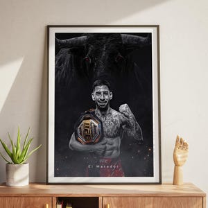 May include: A black and white poster featuring a mixed martial arts fighter holding a championship belt. The fighter is standing in front of a bull with red eyes. The text "El Matador" is at the bottom of the poster.