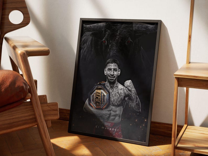 May include: A black and white poster featuring a mixed martial arts fighter holding a championship belt. The fighter is wearing a black tank top and shorts. The poster has a bull's head in the background and the text "El Matador" at the bottom.