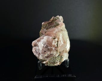 May include: A pink and white crystal cluster with gold flecks, displayed on a black stand.