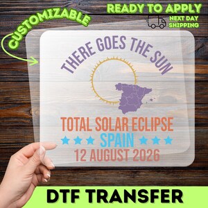 May include: A DTF transfer with the text "THERE GOES THE SUN" and "TOTAL SOLAR ECLIPSE SPAIN 12 AUGUST 2026". The design includes a sun graphic and a map of Spain. The transfer is customizable and ready to apply.